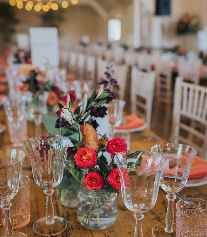 Thorpeness Country Club wedding table decorations, bright flowers and glasses