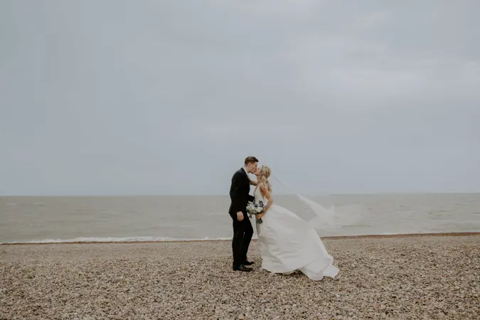 Bride and groom kissing on the beach