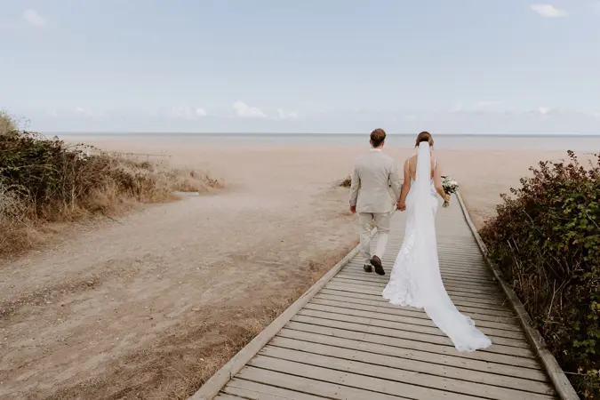 Couple walking down boardwalk to the beach