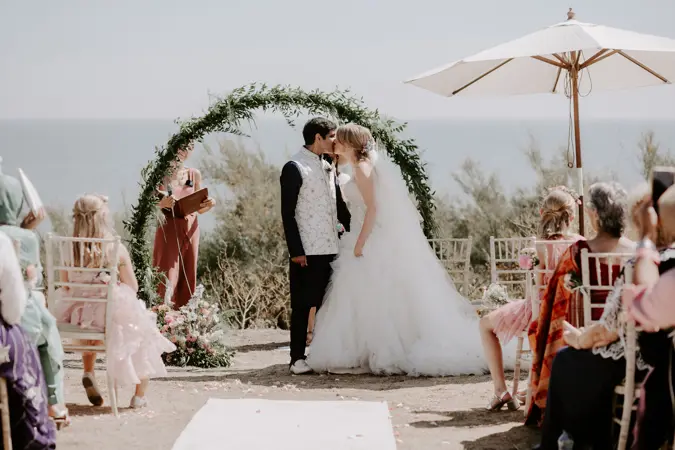 Couple getting married on beach side lawn