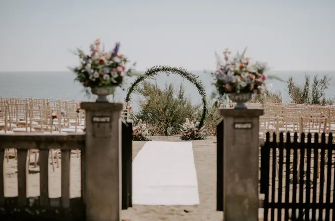 Beach side lawn set up for ceremony with flower wheel